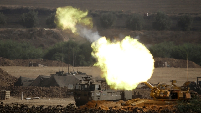 An Israeli artillery gun fires a 155mm shell towards targets from a position near the border