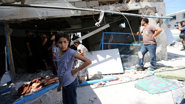 Palestinians inspect a destroyed classroom of the UN school at Jebalya