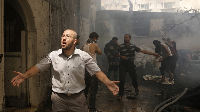 Palestinians try to put out a building on fire following several Israeli strikes on Gaza City