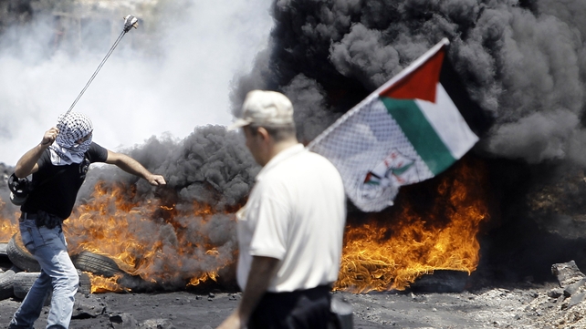 A Palestinian protester slings rocks at Israeli security forces in the village, which is near the northern West Bank city of Nablus