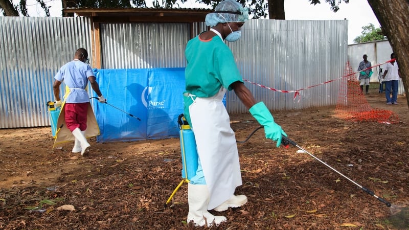 Liberian nurses spray disinfectant as a prevention against Ebola at a medical centre in the capital Monrovia