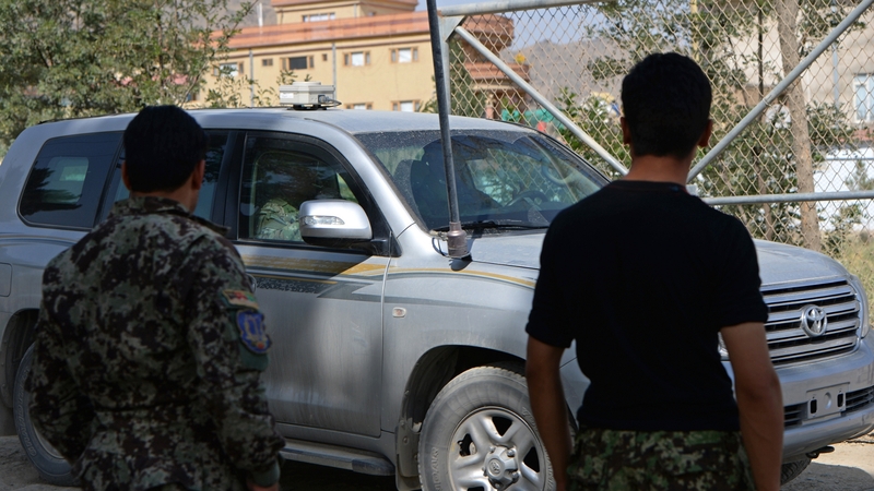 A NATO vehicle departs the military academy on the outskirts of Kabul