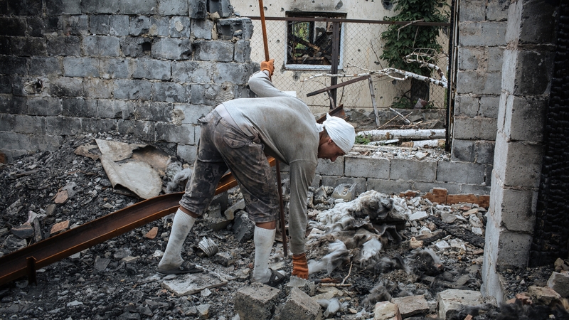 A man tidies up a destroyed cafe after fighting between militants and Ukrainian forces near Slaviansk