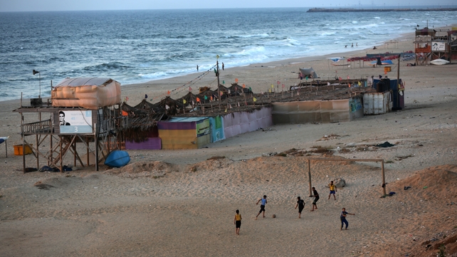 People play football on the beach in Gaza City