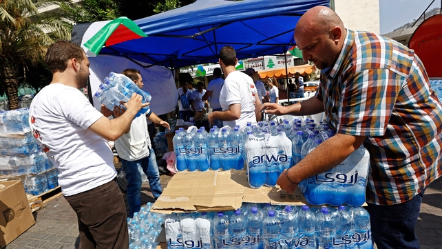 Palestinian volunteers in the West Bank city of Nablus prepare packs of water bottles to distribute to people in Gaza