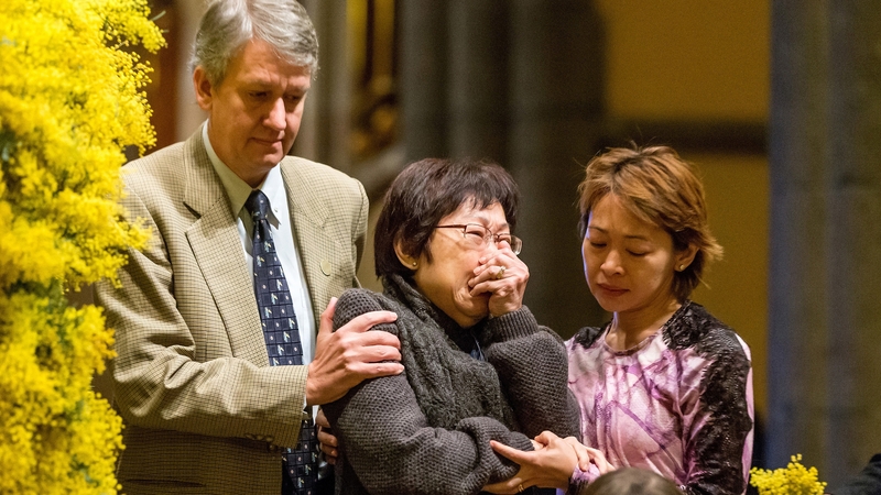 A grieving family member cries during the memorial service in Melbourne