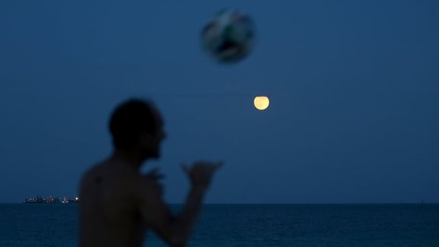 A man plays soccer in Miami Beach, Florida, on the night of the supermoon