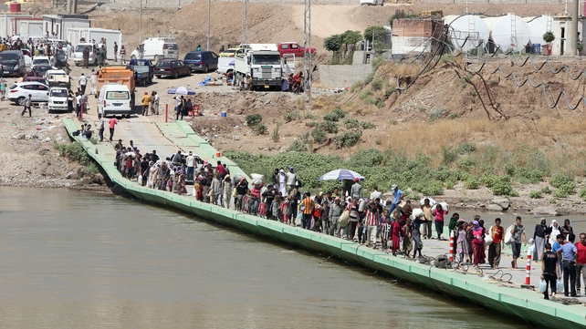 People cross the Fishkhabur Bridge over the Tigris River in northern Iraq