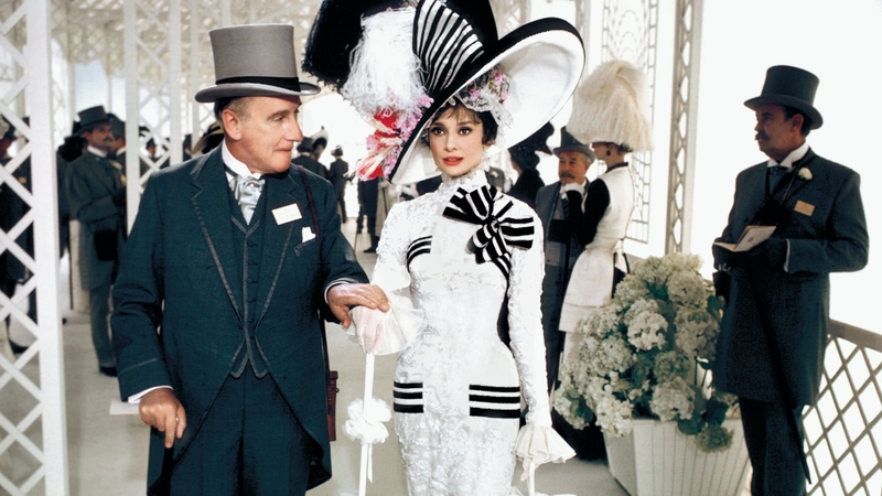Eliza is escorted by Colonel Pickering, played by Wilfrid Hyde-White, on a day at the races at Ascot