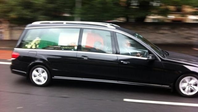 The hearse carrying the former Taoiseach's remains departs for the cemetery