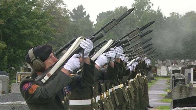 Members of the Defence Forces perform a salute at Mr Reynolds's graveside