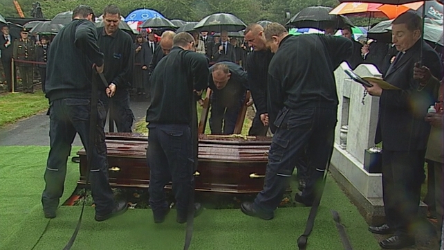 The coffin is lowered to Mr Reynolds's final resting place