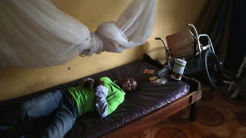 A man lies in an observation room at a government clinic in Dolo Town, Liberia