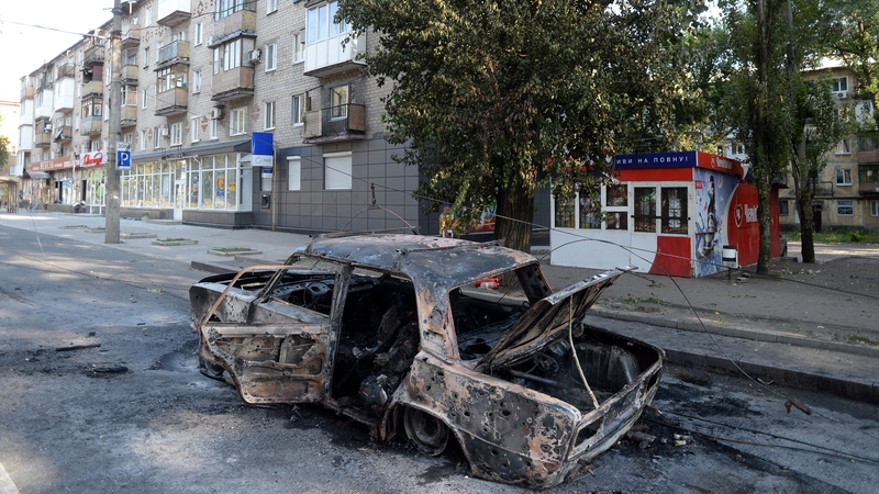 Shelling in Donetsk brought down a tram cable, sitting this car alight and killing three people