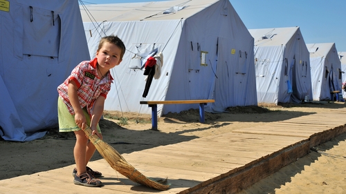 A boy from Eastern Ukraine sweeps the floor at a temporary refugee camp in Donetsk
