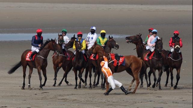 Gary Carroll struggles to keep his balance after falling off Tohugo while his masked colleagues (hoping to protect themselves from the sandy kickback) line up for the start of the O'Neills Sports Handicap
