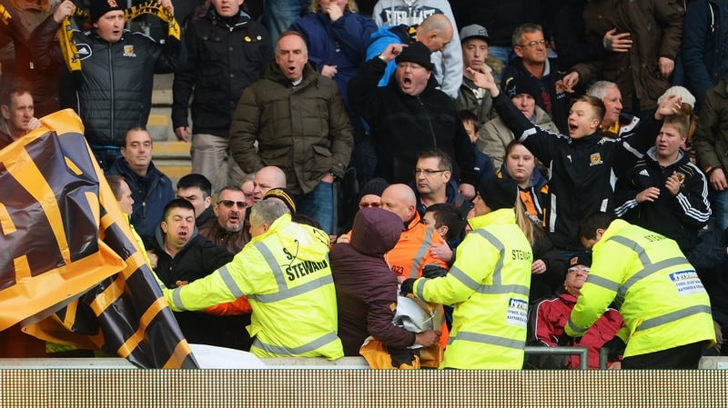 Stewards try to remove a banner from Hull City fans during a protest last November
