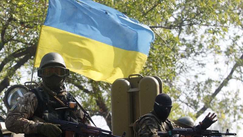 Ukrainian servicemen sit atop of an Armoured Personnel Carrier during a patrol in the Donetsk region