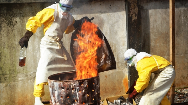 Health workers burn used protection gear at the NGO Medecins Sans Frontieres in Conakry in Guinea