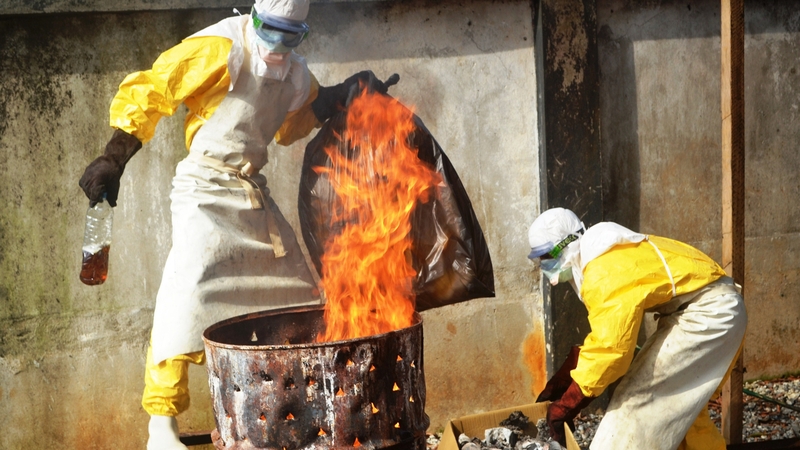 Health workers burn used protection gear at the NGO Medecins Sans Frontieres in Conakry in Guinea