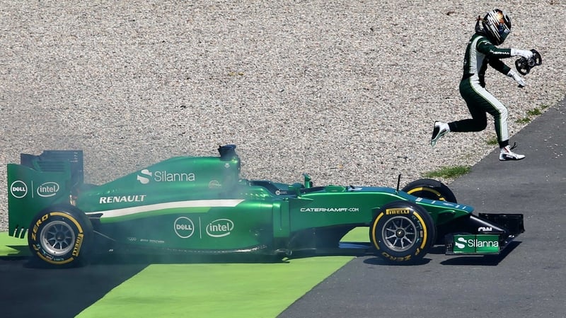 Kamui Kobayashi jumps from his car as smoke rises from it during practice for the German GP in July