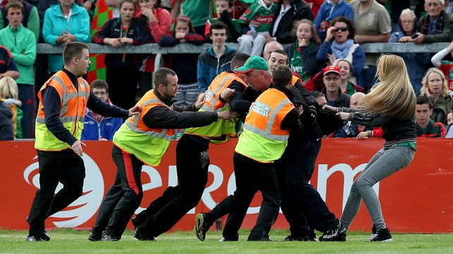 30 August - A Mayo supporter is led off the pitch near the end of the Gaelic Grounds clash