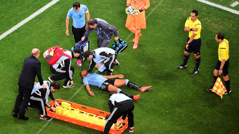 Alvaro Pereira receives treatment after a collision during the World Cup Brazil Group D match between Uruguay and England