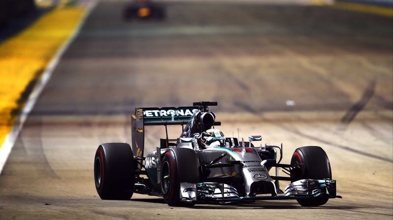 Lewis Hamilton guides his Mercedes clear of the distant blur that is the Red Bull of Sebastian Vettel at the Singapore Grand Prix