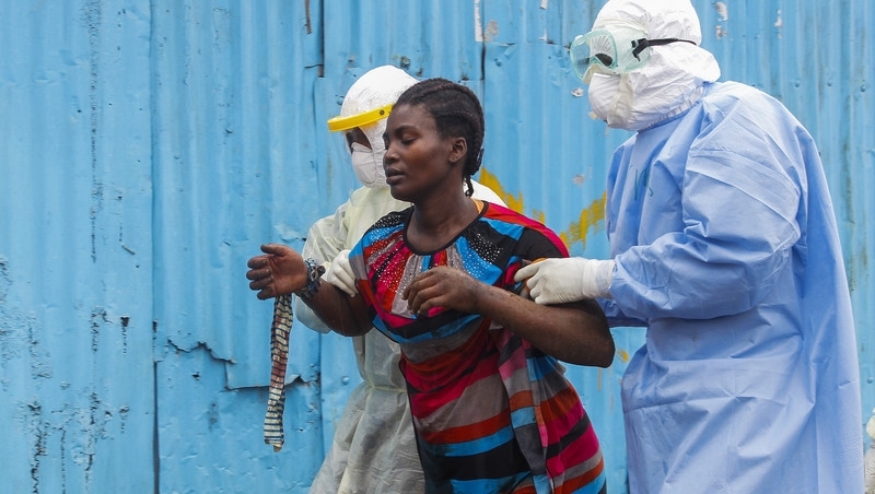 Liberian nurses escort a suspected Ebola patient into a treatment centre in Monrovia, Liberia