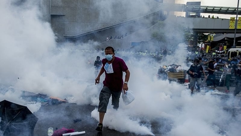 A pro-democracy demonstrator runs as police fired tear gas towards protesters