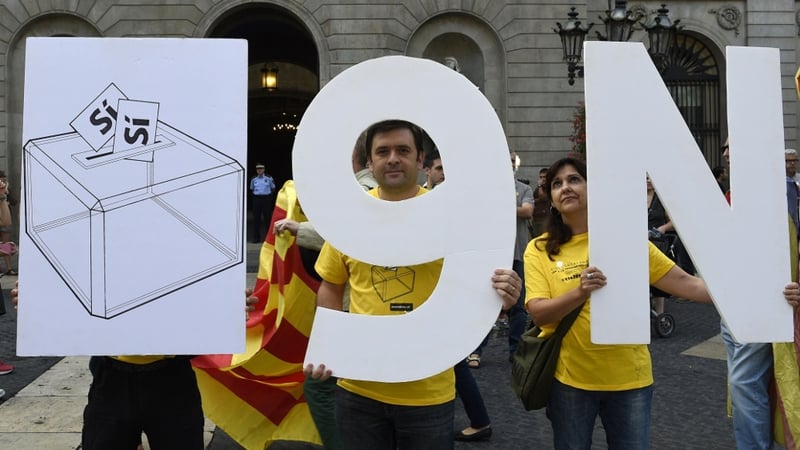 Pro-independence Catalans hold placards representing a ballot box and the date of the vote '9N'