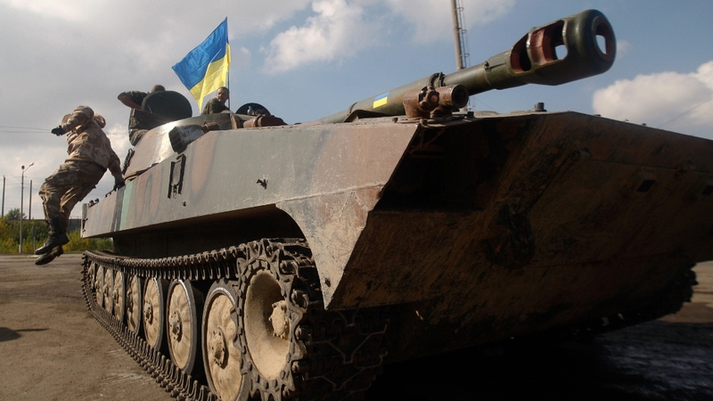 A Ukrainian serviceman jumps off a tank parked near town of Debaltseve in the Donetsk region