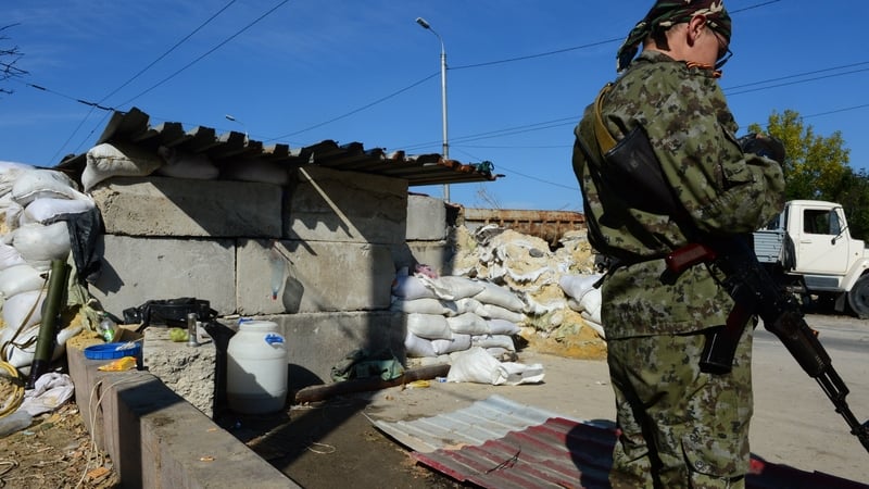 A pro-Russian separatist soldier mans a checkpoint on the road to the airport, still held by the Ukrainian army