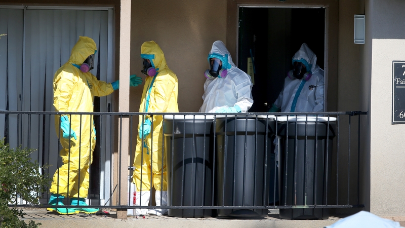Members of a cleaning unit sanitize the apartment where the Ebola patient previously stayed