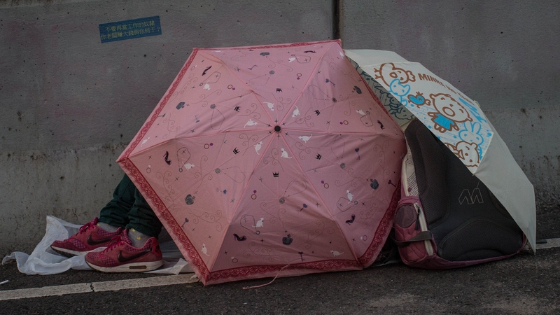Protesters shelter under umbrellas overnight