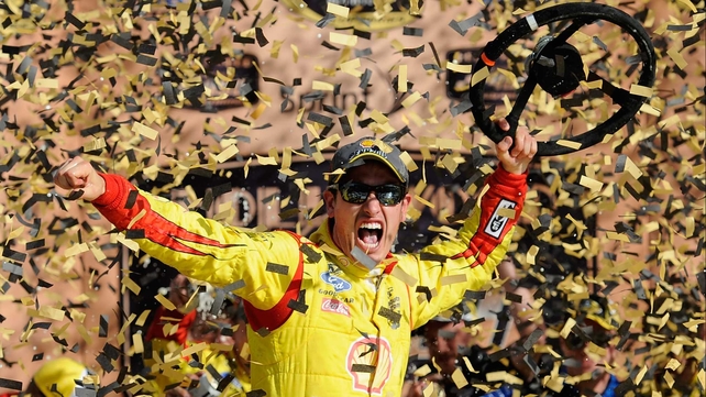 Shell-Pennzoil Ford's Joey Logano celebrates after winning the NASCAR Sprint Cup Series Hollywood Casino 400 at Kansas Speedway