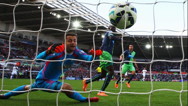 Newcastle's Papiss Demba Cisse heads past Lukasz Fabianski in the Swansea goal