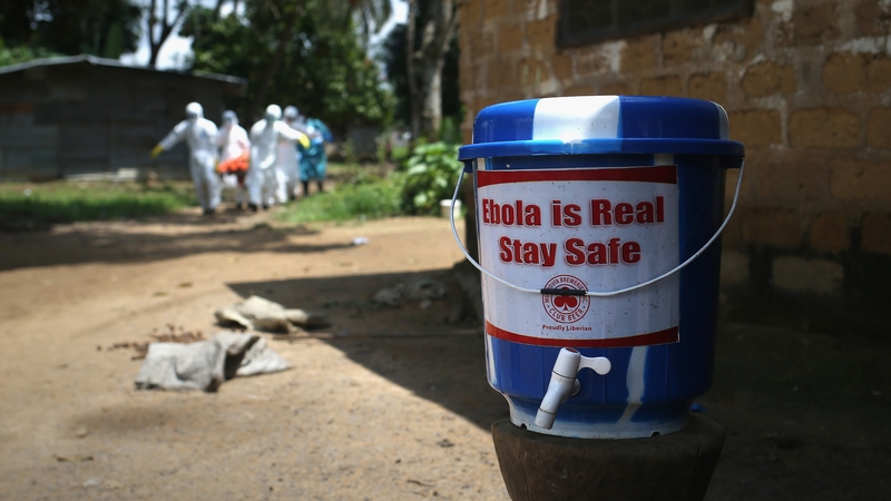 Workers prepare to bury the body of an Ebola victim