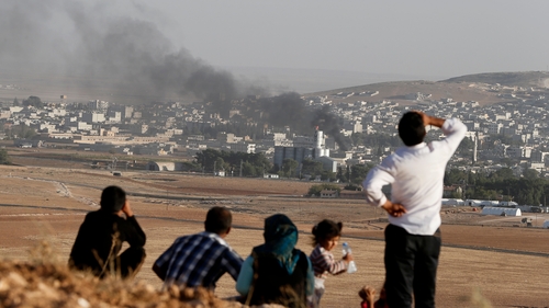 People watch from Turkey as smoke rises over Kobane after an apparent air strike