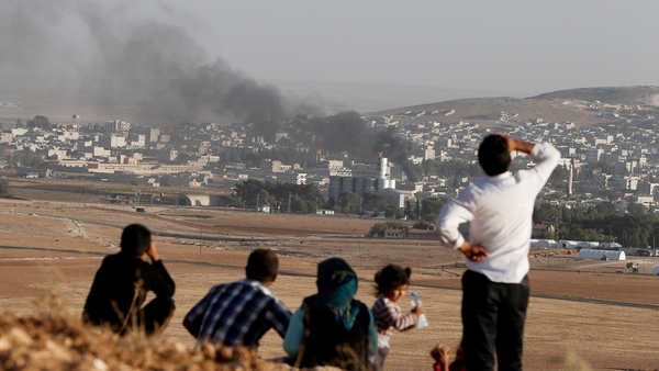People watch from Turkey as smoke rises over Kobane after an apparent air strike