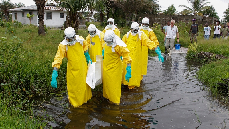A team carries the body of an Ebola victim for burial