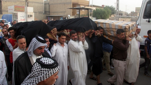 Iraqis carry the coffin of three victims killed in a car bomb attack in Iraq