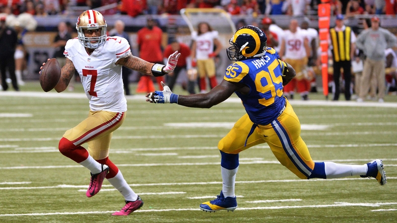 Colin Kaepernickof the San Francisco 49ers tries to avoid the tackle of William Hayes of the St Louis Rams in the fourth quarter at Edward Jones Dome