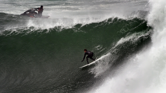 A surfer battles the giant waves as gale force winds, torrential rain and snow wreaked havoc across Sydney and surrounding areas