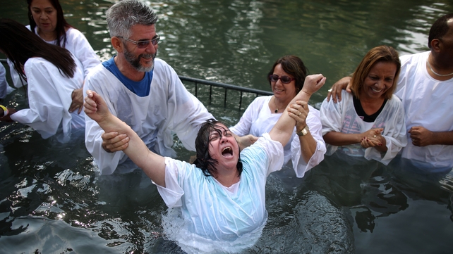 Christian pilgrims from Brazil are baptised in the Jordan River alongside the Sea of Galilee at the popular Yardenit site