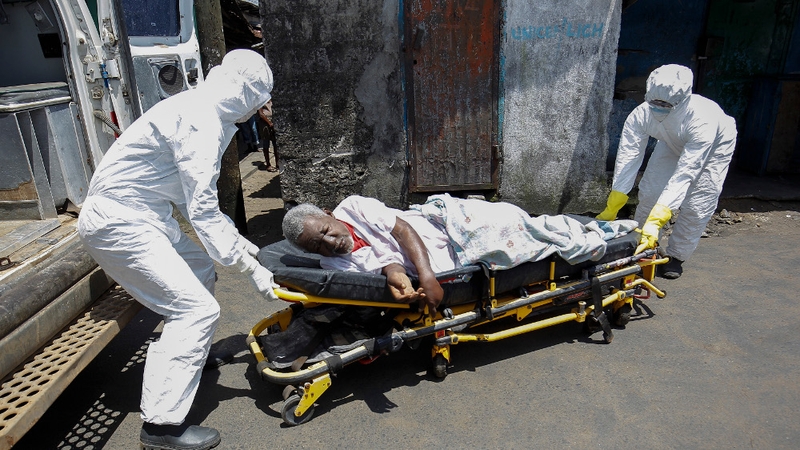 A Liberian ambulance team transport a suspected Ebola patient from the township of West point in Monrovia
