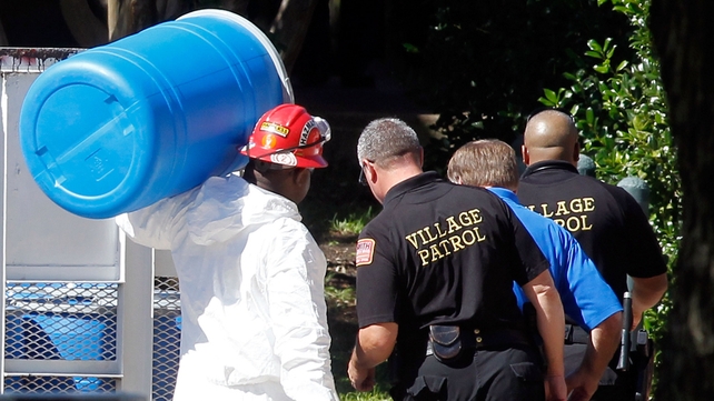 A hazmat worker carries a barrel in preparation for decontaminating of the apartment of a health care worker who tested positive for ebola in Texas