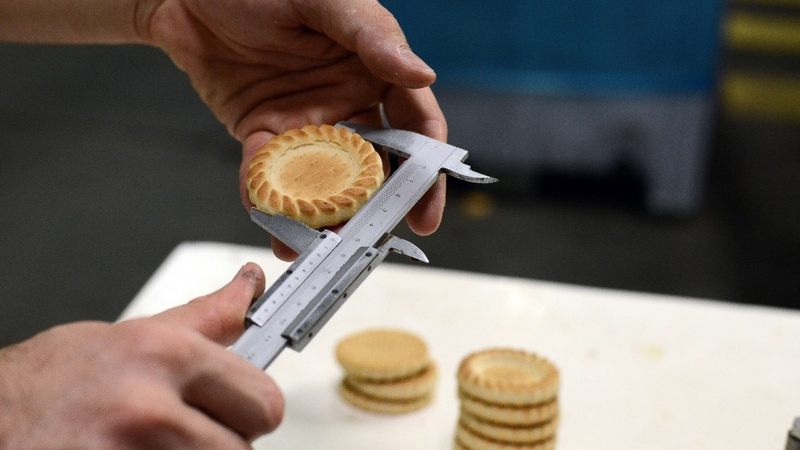 A technician at the French firm Poult, which specialises in the manufacture of biscuits for supermarkets, checks the size of a product