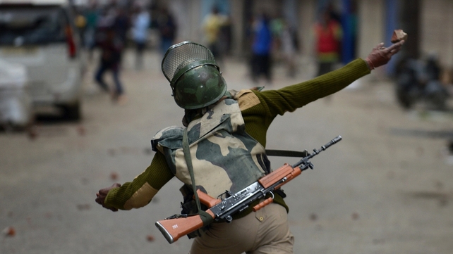 Indian police throw stones during clashes with flood-affected Kashmiri residents protesting against the state government in Srinagar