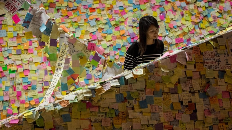 A woman looks at pro-democracy notes stuck to a stairwell outside Hong Kong's government complex